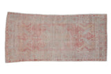 Vintage distressed Oushak rug runner with a faded shield medallion in soft raspberry and silver.