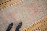An at-feet perspective showing the low-pile texture of the vintage distressed Oushak runner.