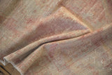 Hand-knotted pile of a distressed Oushak rug showing its even wear and soft, faded raspberry tones.
