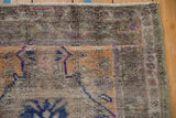 Distressed Oushak rug close-up, revealing worn pile, vibrant magenta, and cobalt blue.