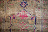 Distressed vintage Oushak rug showing worn pile texture, foundation visible, with magenta and blue patterns.