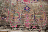 Textured pile of a distressed Oushak rug, revealing magenta, cobalt, and pale brown tones.
