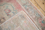 Vintage Oushak rug corner showing the hand-knotted back and distressed, low-pile texture.