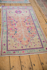 Distressed vintage Oushak rug: upper right corner with dusty teal and magenta geometric border.