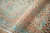 Distressed Oushak rug, showing worn pile texture in soft cantaloupe, blue, and beige.