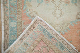Distressed vintage Oushak rug detail: worn pile and visible hand-knotted foundation.