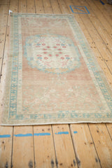 Corner of distressed Oushak runner: ocean blue-green cloudband spandrel, dusty red floral motifs.