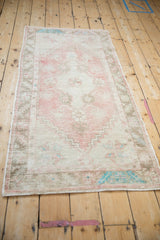 Angled view of a distressed Oushak runner highlighting its soft dusty rose and sage patina.