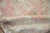 The distressed texture and even wear of the vintage Oushak rug's soft, low pile.