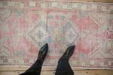 Distressed Oushak runner in blush, slate blue, and sand, showing shield medallion and even wear.
