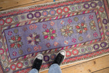 Distressed Oushak runner with soft lavender pile, starburst florals, and vibrant border.
