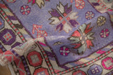 Distressed Oushak runner pile, featuring faded starburst floral and pomegranate motifs in lavender, pink.