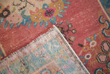 Distressed Oushak runner showing hand-knotted reverse, intact selvage, and worn raspberry red pile.