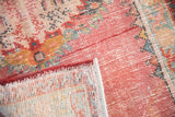 Close-up of distressed Oushak runner pile, showing worn raspberry red, exposed foundation, and side selvage.