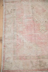Detail of the vintage runner's low pile, showing its distressed texture and secured side cord.
