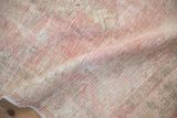 Close view of the distressed texture showing worn knot heads in pale pink and silver tones.