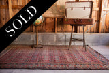 Antique Malayer rug showcasing cranberry and blue tribal motifs with nuanced wear.