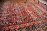 Antique Malayer rug's cranberry field, tribal patterns in blue and beige, with visible foundation wear.