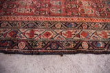 Antique Malayer tribal rug's worn border and edge, revealing cranberry and blue geometric patterns.