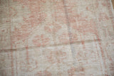Distressed Oushak runner pile, with dusty blush floral motifs and visible neutral foundation.