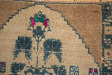 A floral blossom with rose and green details on the even-worn, hand-knotted wool pile.