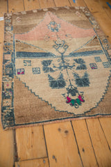 A vintage Kars rug showing its tree of life design pointing toward a dusty rose partial prayer arch.
