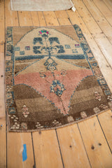 Angled view of a vintage Kars rug showing its tree of life design and distressed, earthy palette.