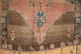 Worn texture of a vintage Kars rug with a dusty rose and sapphire blue prayer design.