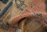 A soft fold reveals the thick pile and blanket-like texture of a distressed vintage Kars rug.