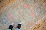 The soft, time-worn texture and scale of a distressed Oushak rug in pale pink, jade, and blue.