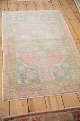 A vintage distressed Oushak rug's low pile and time-softened texture seen from an angle.