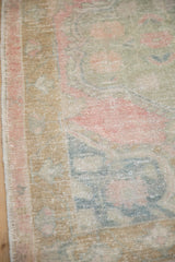 Evenly worn pile of a vintage Oushak rug showing faded pink, jade, and dusty gold colors.