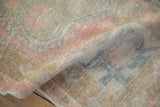 Evenly worn, low pile texture shown on a folded corner of a vintage Oushak rug.