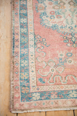 Distressed vintage Turkish Oushak rug showing even wear with dusty pink, turquoise, and ivory patterns.