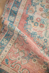 Vintage distressed Oushak rug texture, soft dusty pink and turquoise floral motifs, with even pile wear.