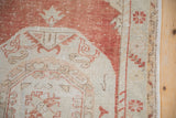 Corner spandrel and floral border detail on a distressed Oushak rug with low pile texture.