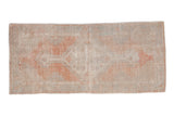 Distressed vintage Oushak runner with a faded diamond medallion in dusty sandalwood, blush, and pale blue.