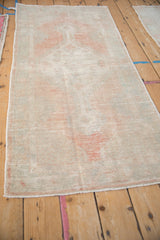 Angled view of a vintage Oushak runner highlighting its distressed texture and faded colors.