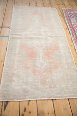 Lengthwise view of the distressed Oushak runner showing its soft low pile and faded pattern.