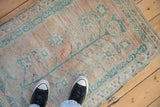 The blanket-like texture of a distressed Oushak rug with faded saffron and dusty teal colors.