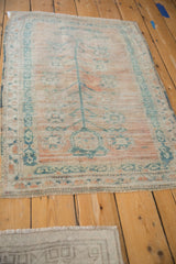 Distressed Oushak rug from an angle, showing its soft, malleable wool and faded saffron tones.