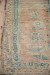 Even wear across the thick wool pile and geometric serpent border of a distressed Oushak rug.