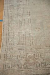 Low pile texture of a distressed Oushak rug, showing visible knot heads and a faded geometric border.