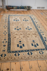 Close-up of Vintage Distressed Afghani rug pile, showcasing dark sapphire blue geometric border on an ivory field.