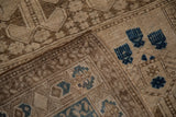 Distressed vintage Afghani rug corner, showing dark sapphire blue motifs, worn pile, and selvage.