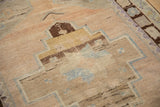 Distressed Oushak rug detail: worn pile texture, geometric brown and blue motifs.