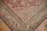 Distressed Anatolian rug corner, with faded red arabesque field and peach pomegranate spandrel.