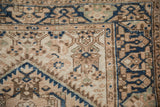 Vintage Distressed Hamadan rug corner: cobalt blue serpent border and pale coffee brown field patterns.