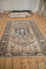 Distressed cobalt blue serpent and plant motif borders on a vintage Hamadan rug.