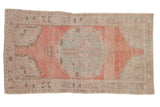 Distressed Oushak rug: abrashed blush pink field, seafoam green medallion, floral motifs. 3'6